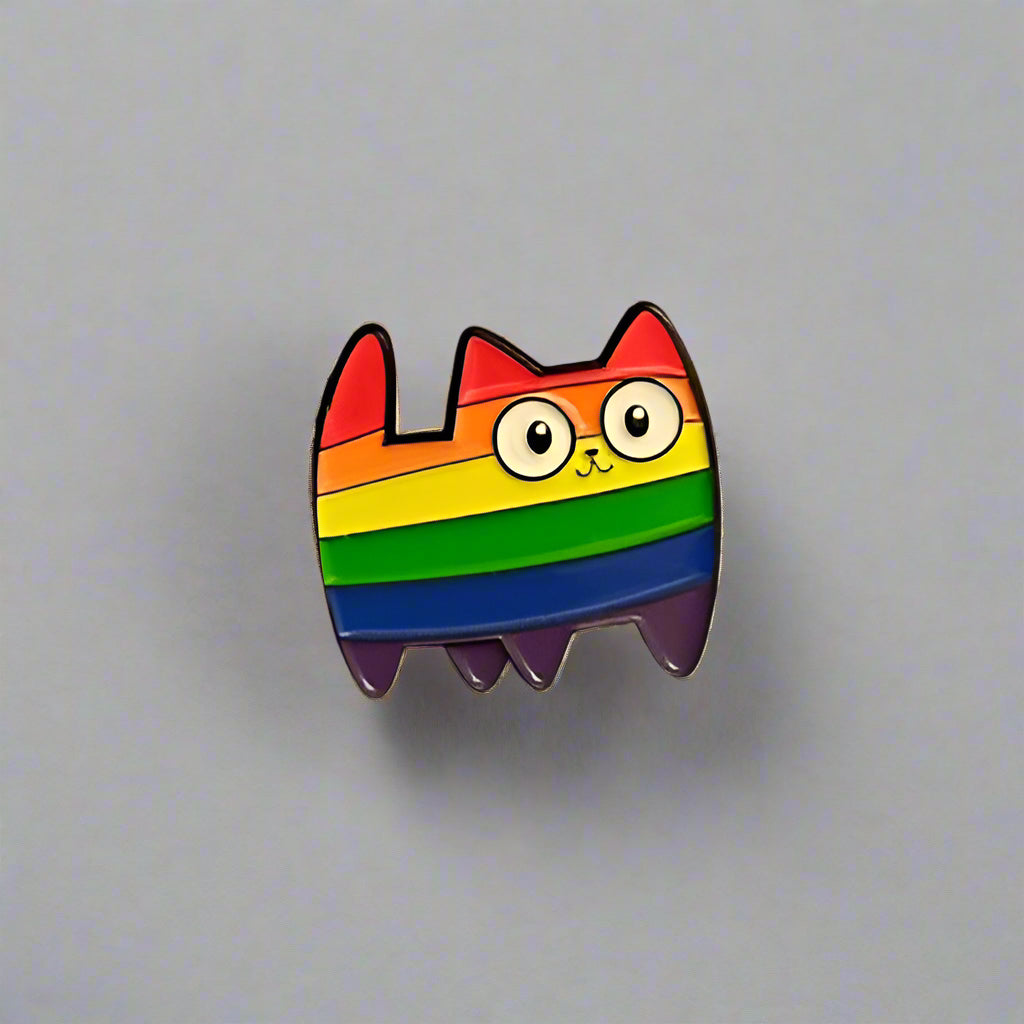Rainbow cat-shaped pin on a light gray surface