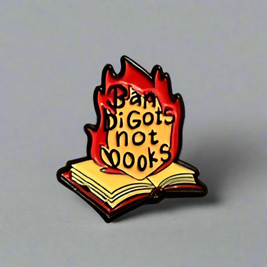 Pin with a book design and text on a gray surface