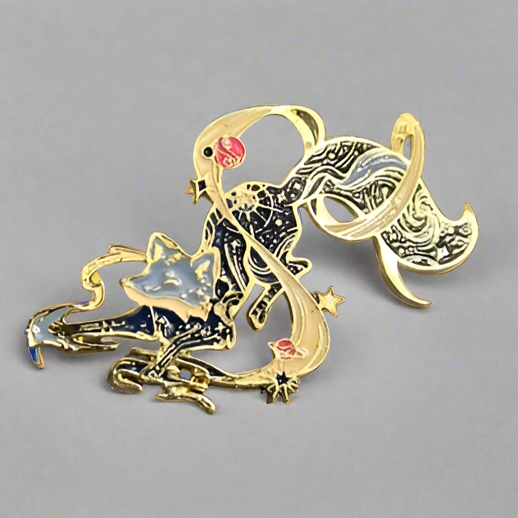 Decorative keychain with a cat and fish design on a gray surface