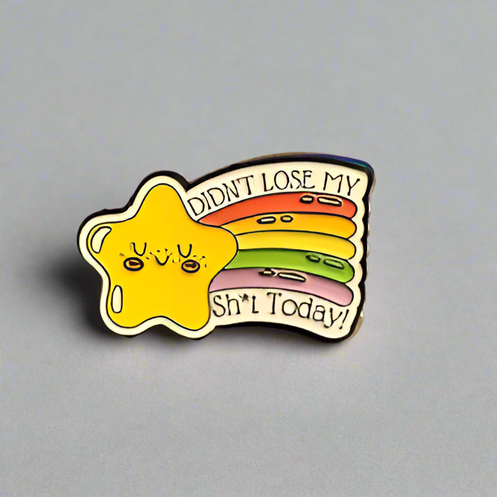Star-shaped pin with a yellow face and text on a gray surface