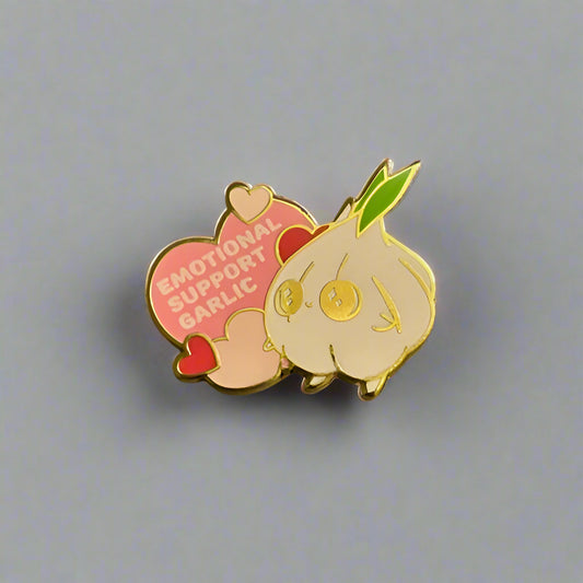 Pin with cartoon garlic character and heart-shaped sign on a gray background