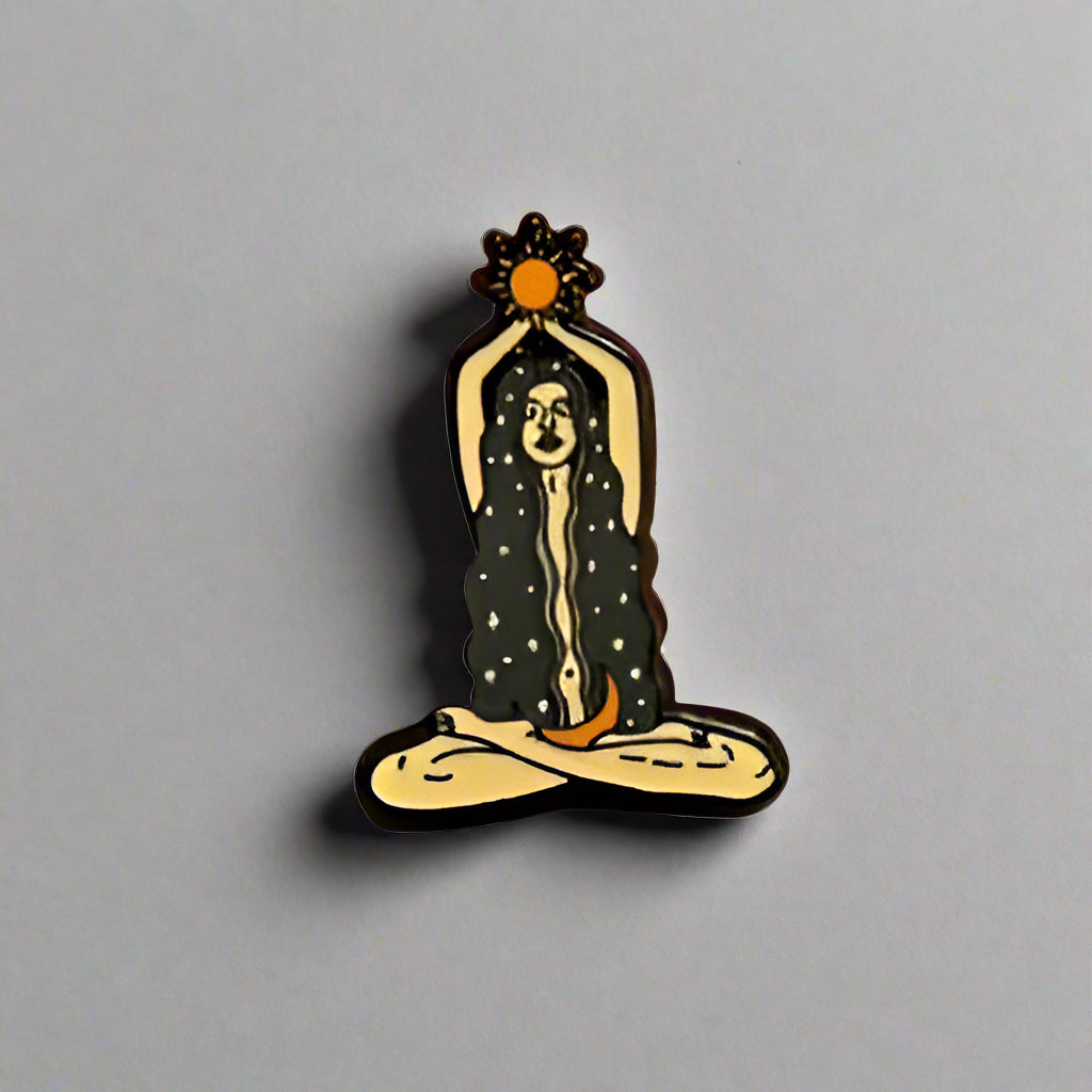 Hand holding a small decorative item on a gray surface