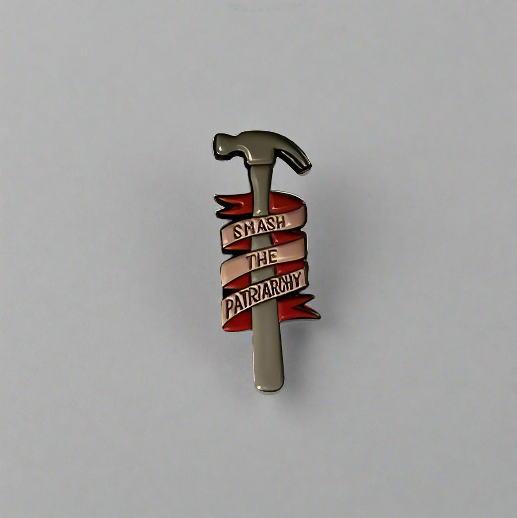 Pin with a hammer design on a white and blue base against a gray background