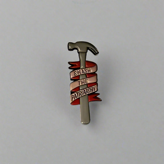 Pin with a hammer design on a white and blue base against a gray background