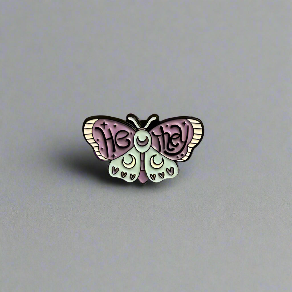 Butterfly-shaped pin with 'Heidi' text on a beige background
