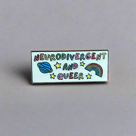 Pin with 'Neurodivergent and Queer' text on a wooden surface