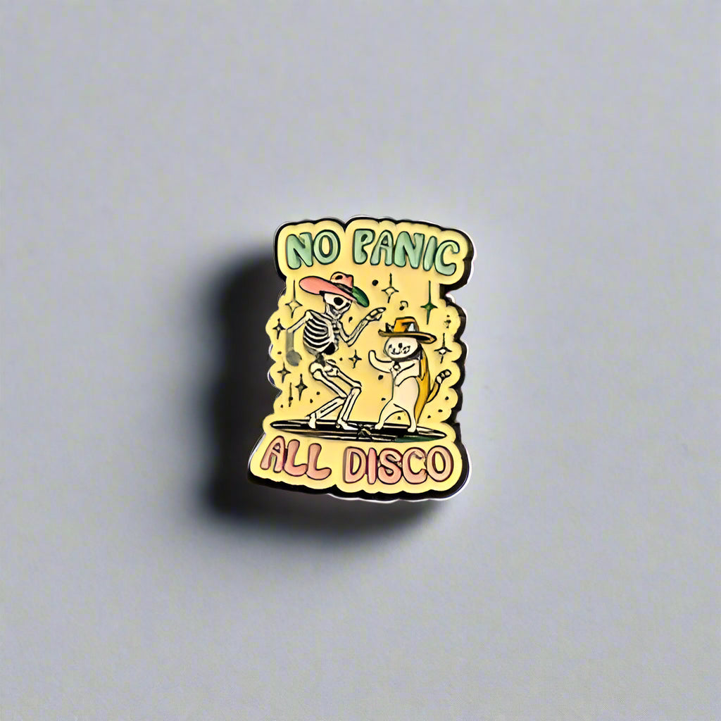 Pin with 'No Panic All Disco' text on a gray surface