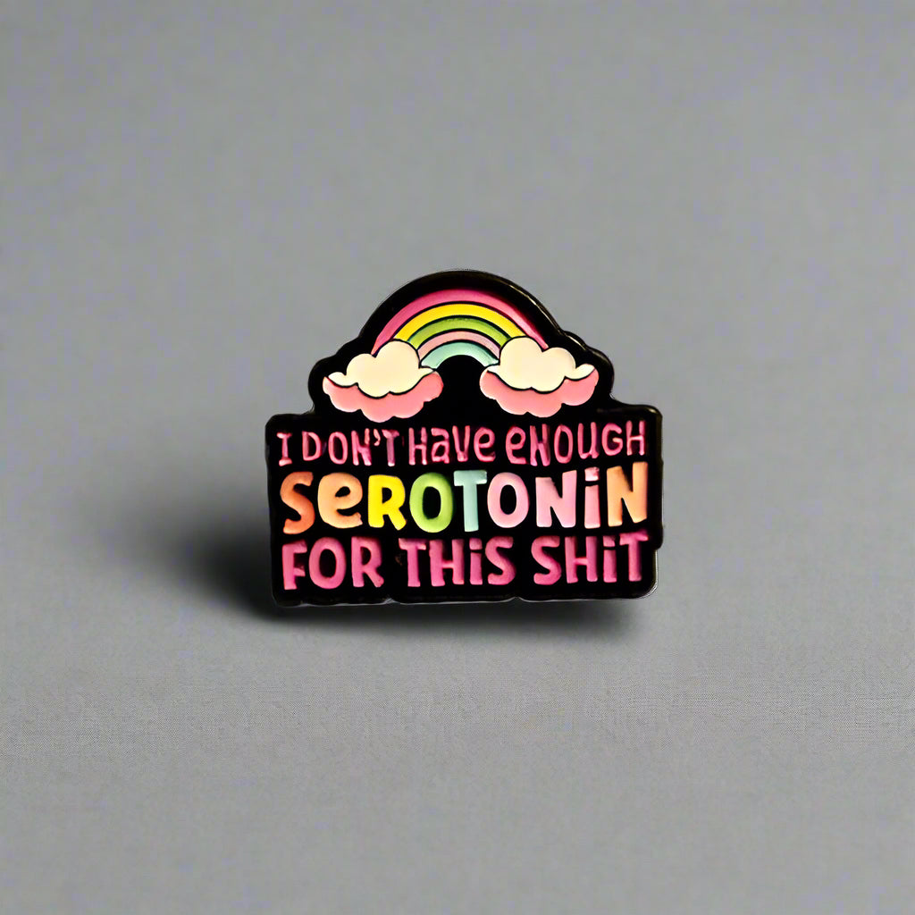 Pin with rainbow and text on a plain background