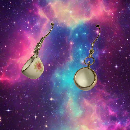 Tea cup-shaped earrings on a jewelry card with a gray background