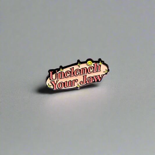 Small metallic badge with text on a plain background