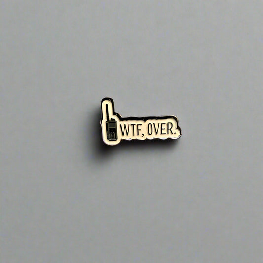 Pin with 'WTF. OVER.' text on a gray surface